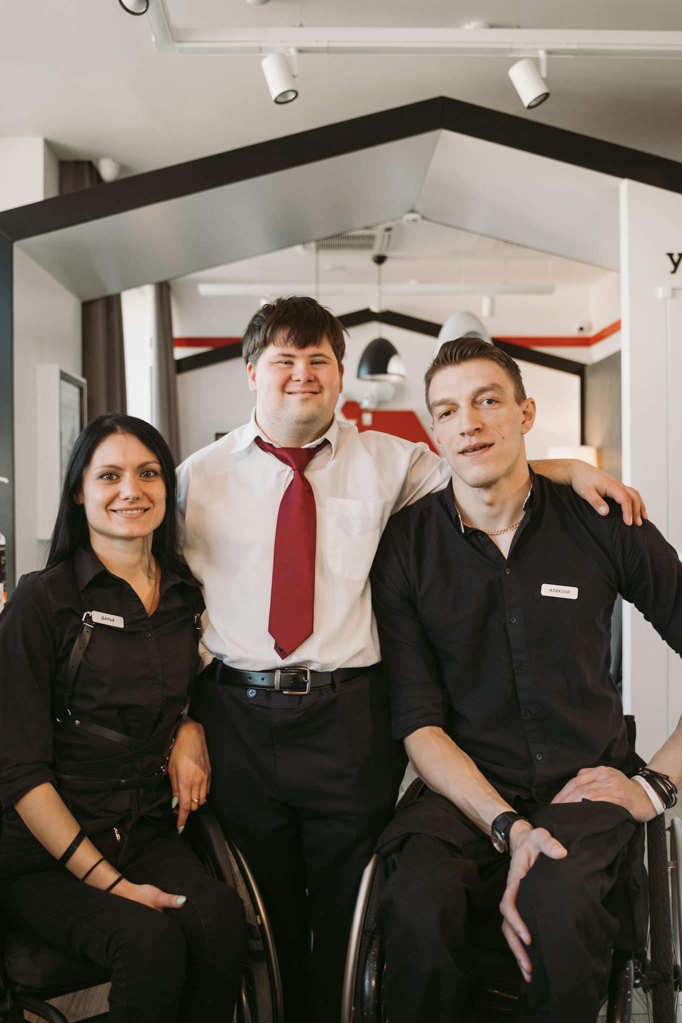 Three colleagues with disabilities enjoying a moment at their workplace, showcasing teamwork and diversity.